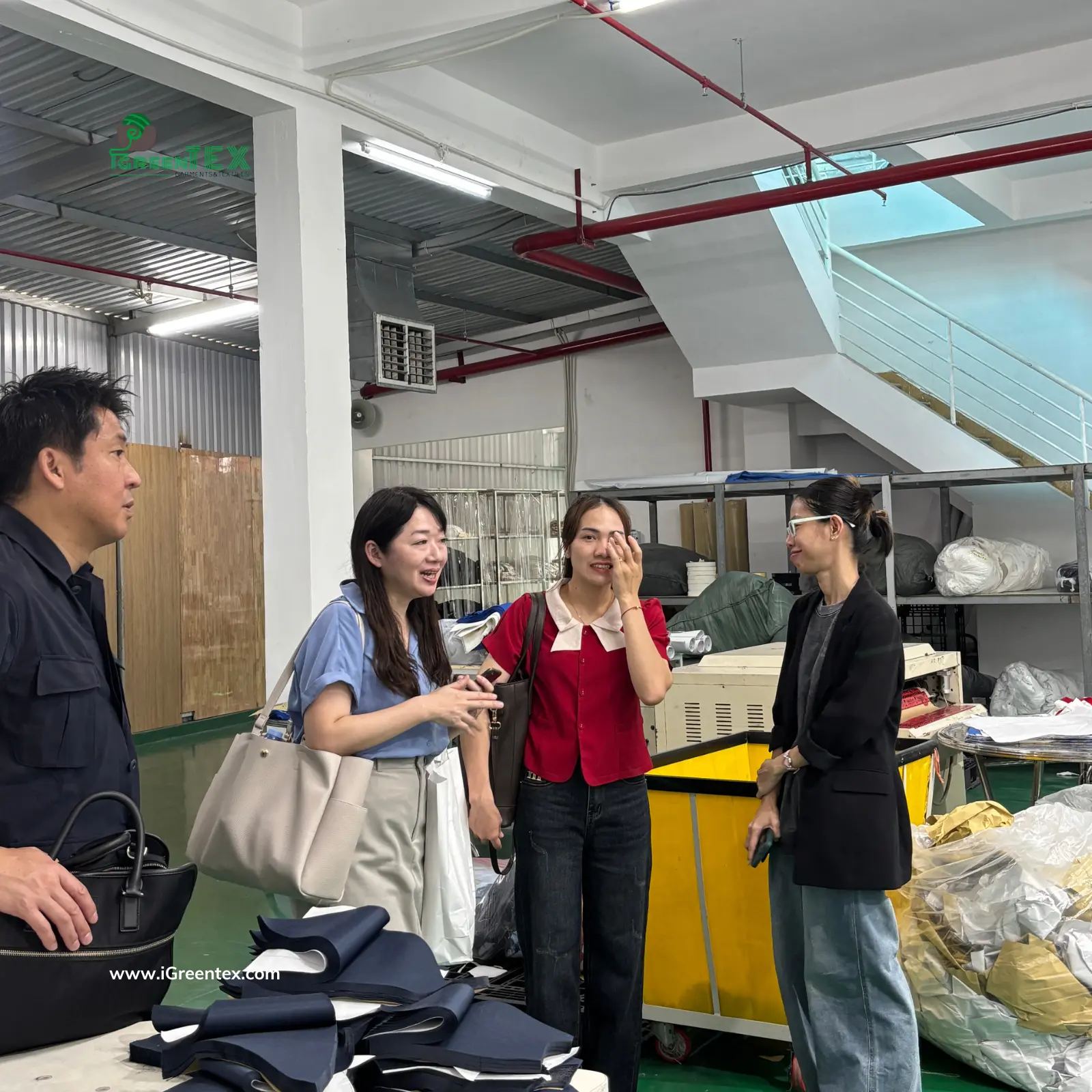 Japanese sourcing auditors inspecting fabric rolls in the warehouse and reviewing precision at the cutting table of iGreen Tex Vietnam. This on-site verification confirms why iGreen Tex is a preferred partner among clothing manufacturers in vietnam for japanese brands for high-quality apparel.