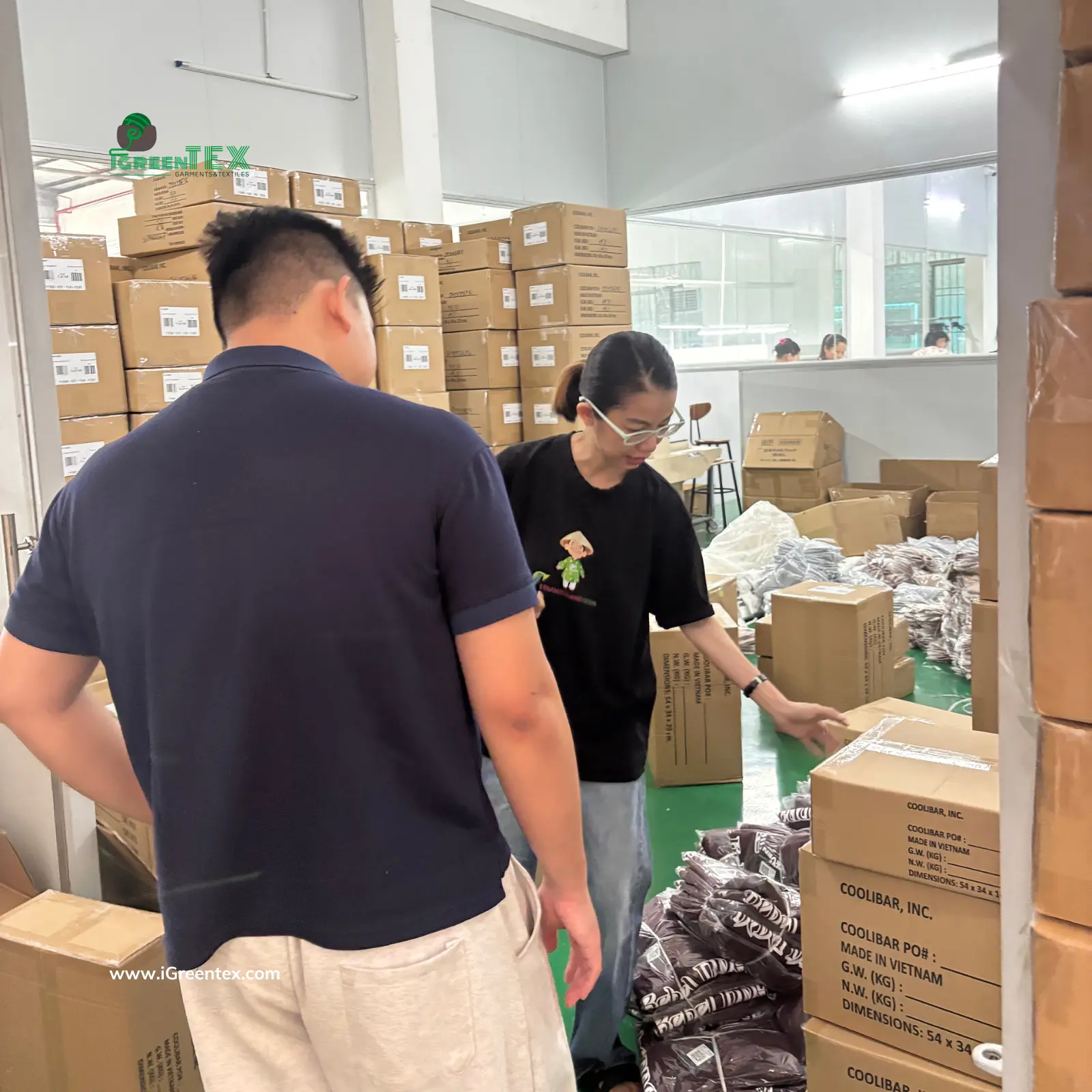 International clients conducting a final inspection of finished garments for FOB shipping at iGreen Tex Vietnam. This scene illustrates the export-ready phase in the textile manufacturers vs cloth manufacturers supply chain.