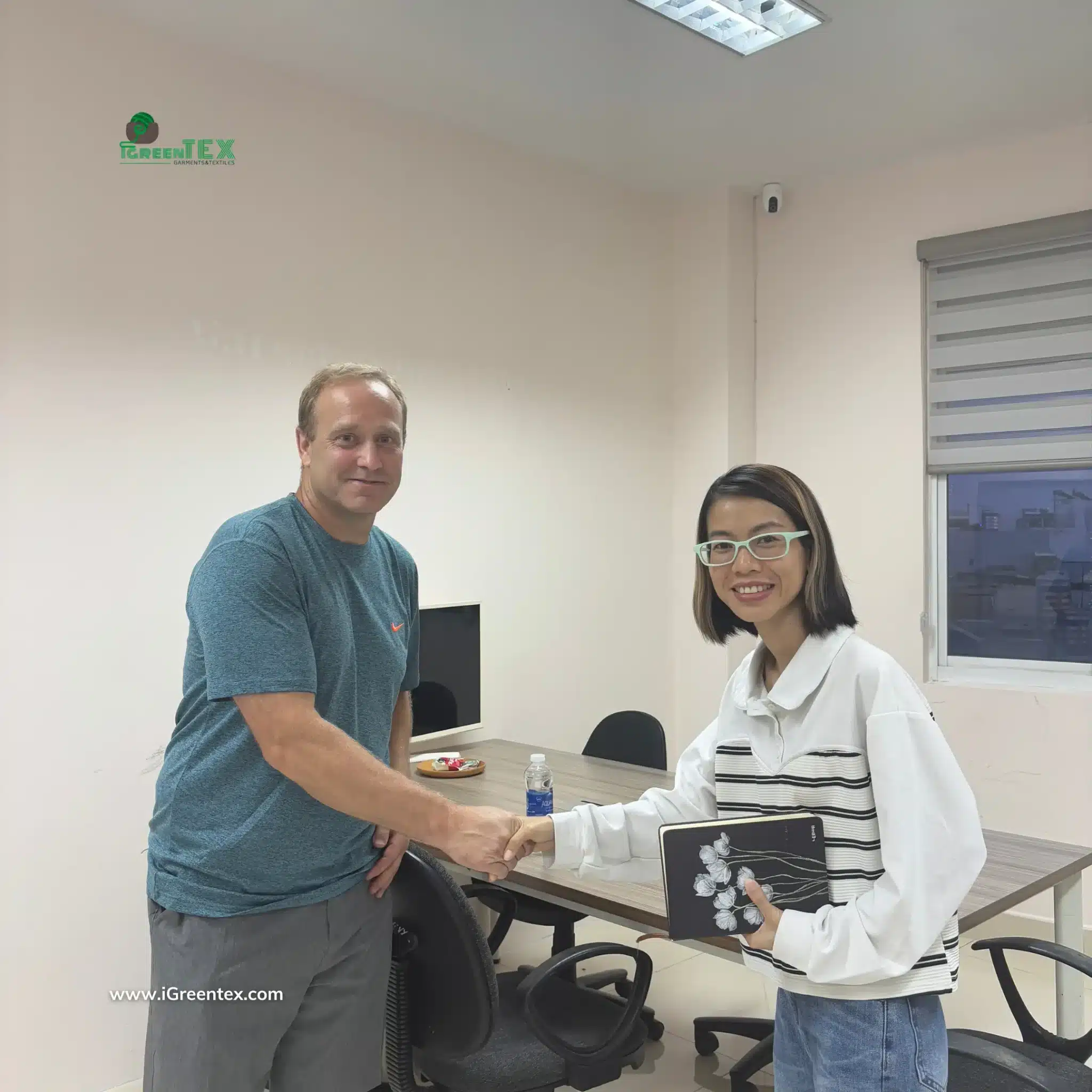 Client reviewing apparel samples and materials at iGreen Tex office