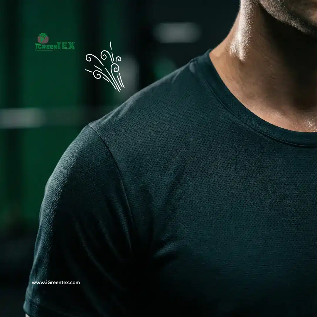 Close-up of an athlete wearing a deep teal black running shirt made from coffee fabric, highlighting the breathable micro-weave texture and fast-drying moisture wicking technology.