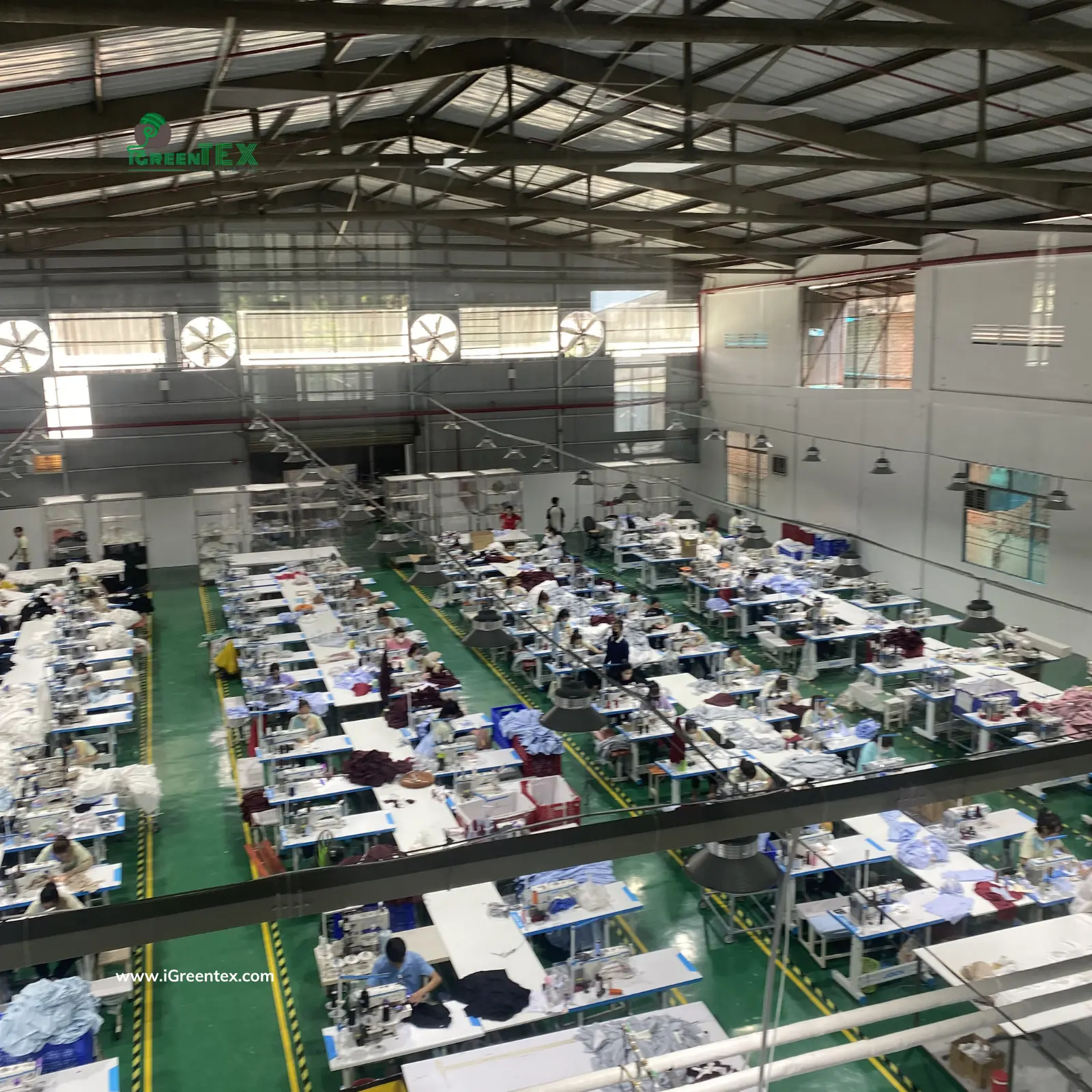 Overhead view of four active sewing lines at iGreen Tex garment factory in Ho Chi Minh City, showcasing large-scale OEM apparel production capacity.