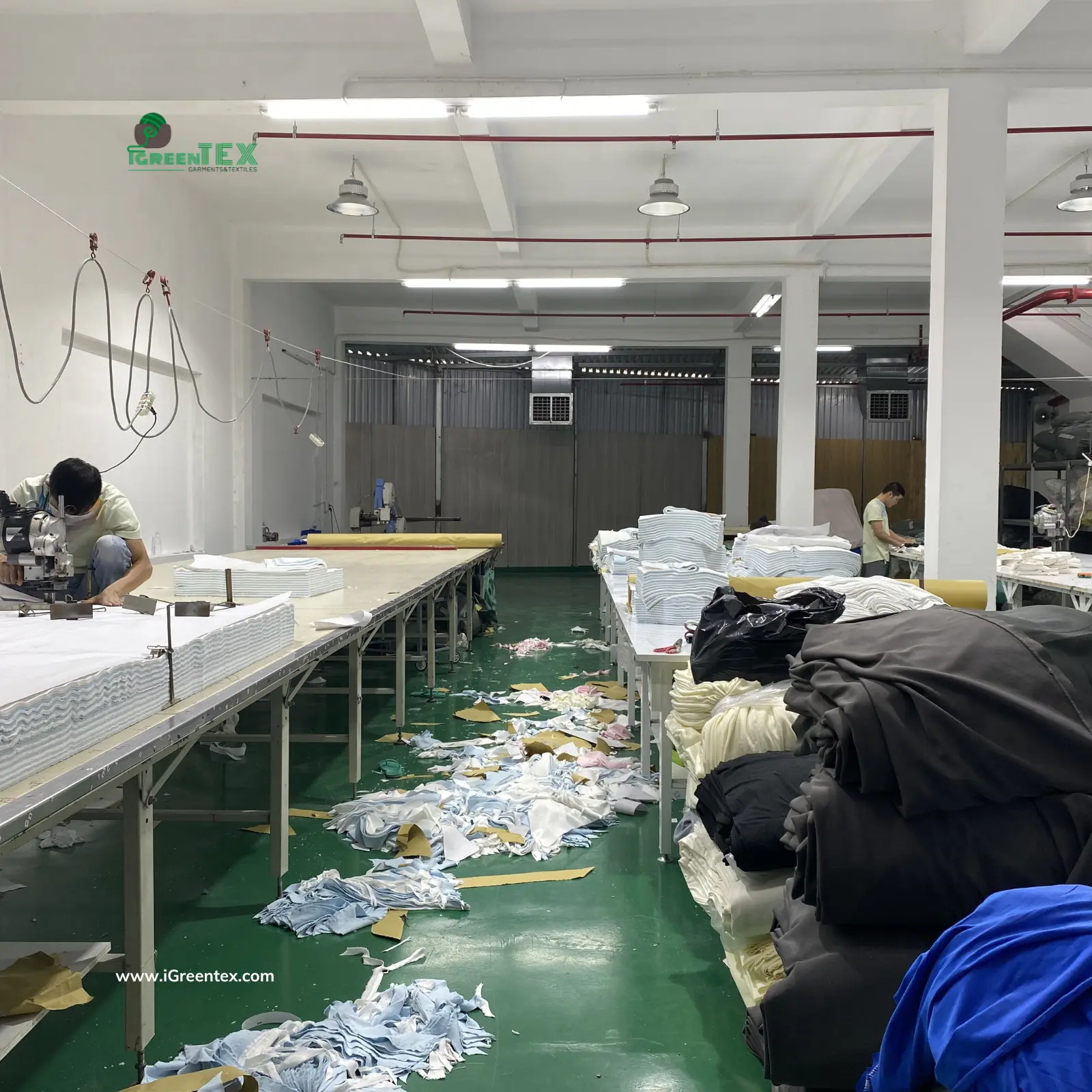 Close-up of GRS and OEKO-TEX certified recycled and organic fabrics being prepared in the cutting room at iGreen Tex Vietnam for ESG compliant production.