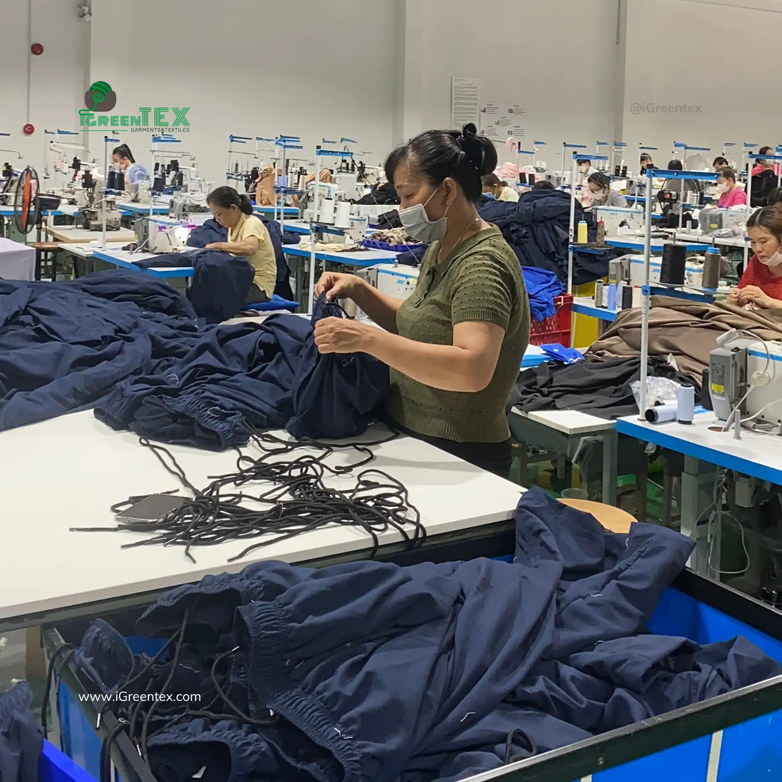 An internal QC inspector checking seams using AQL 2.5 for OEM clothing manufacturing.