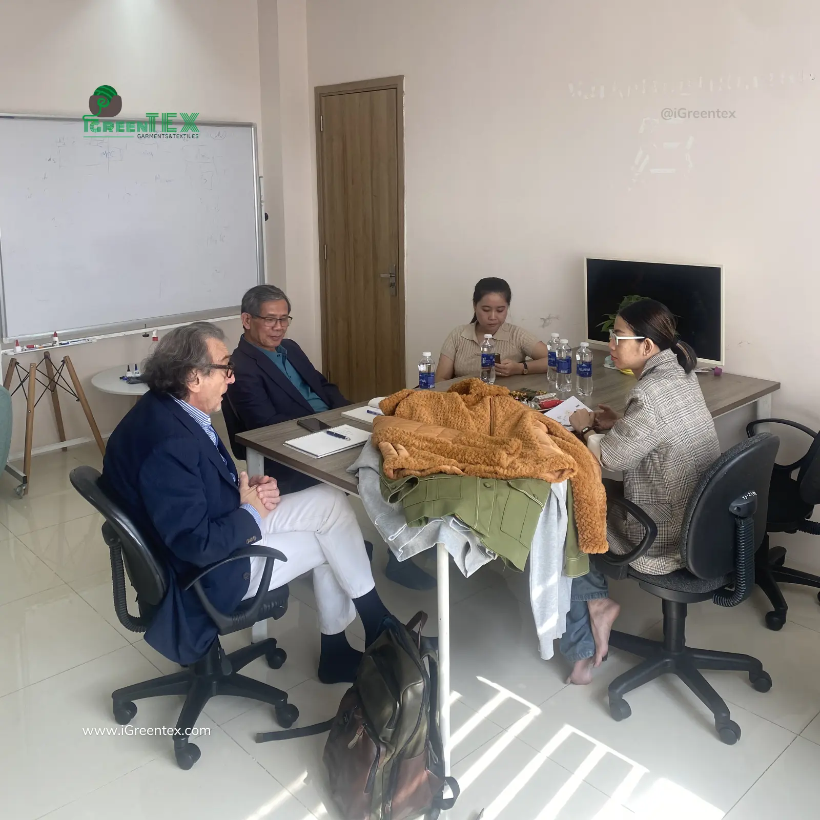 iGreen Tex Vietnam team consulting a client in the meeting room before an apparel factory audit.